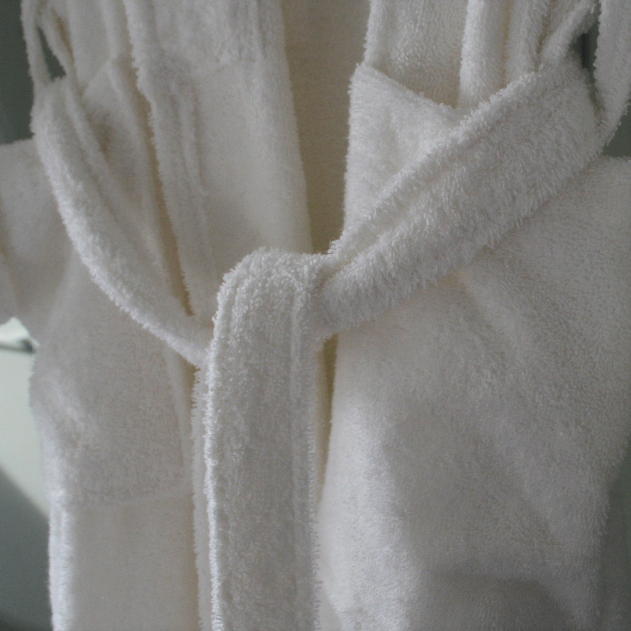 White hotel bathrobe, luxury softness. Towelling robe with belt tie.