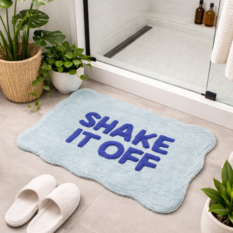 Fun blue scalloped bath mat with shake it off slogan.