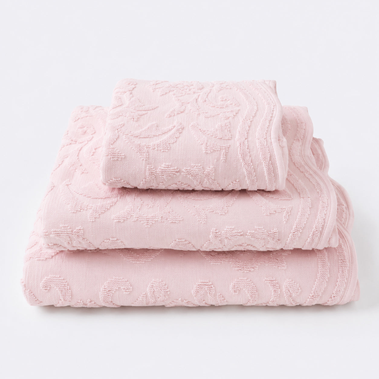 Set of towels for the bathroom with textured floral pattern - hand towel, bath towel and bath sheet in blush pink.