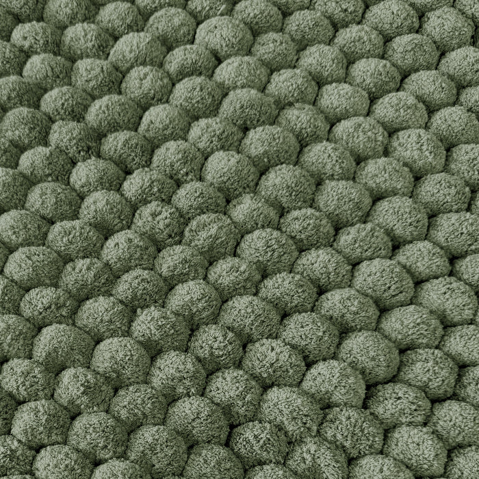 Green textured bobble bath mats close up.