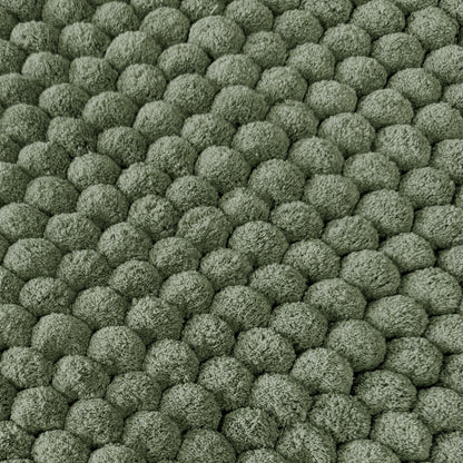 Green textured bobble bath mats close up.