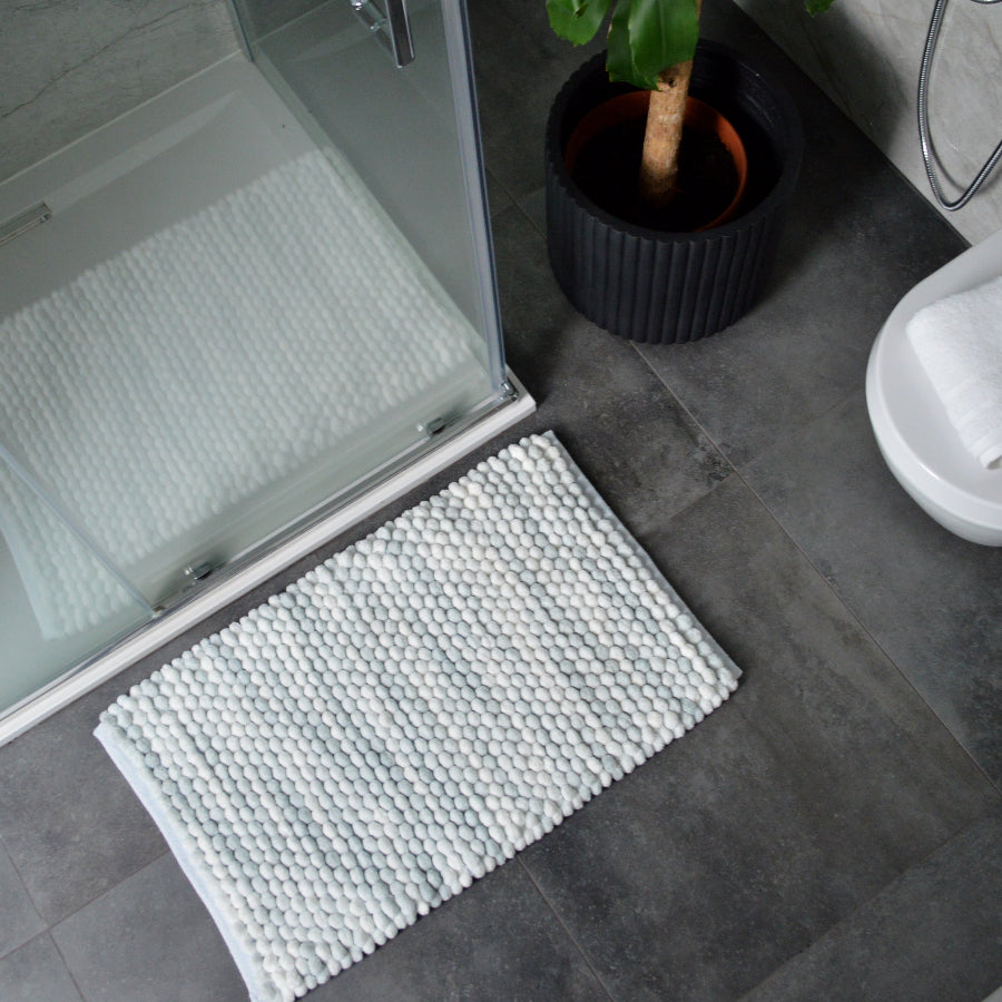 Grey and white bathroom rugs in modern marble pattern with chunky textured bobbles.