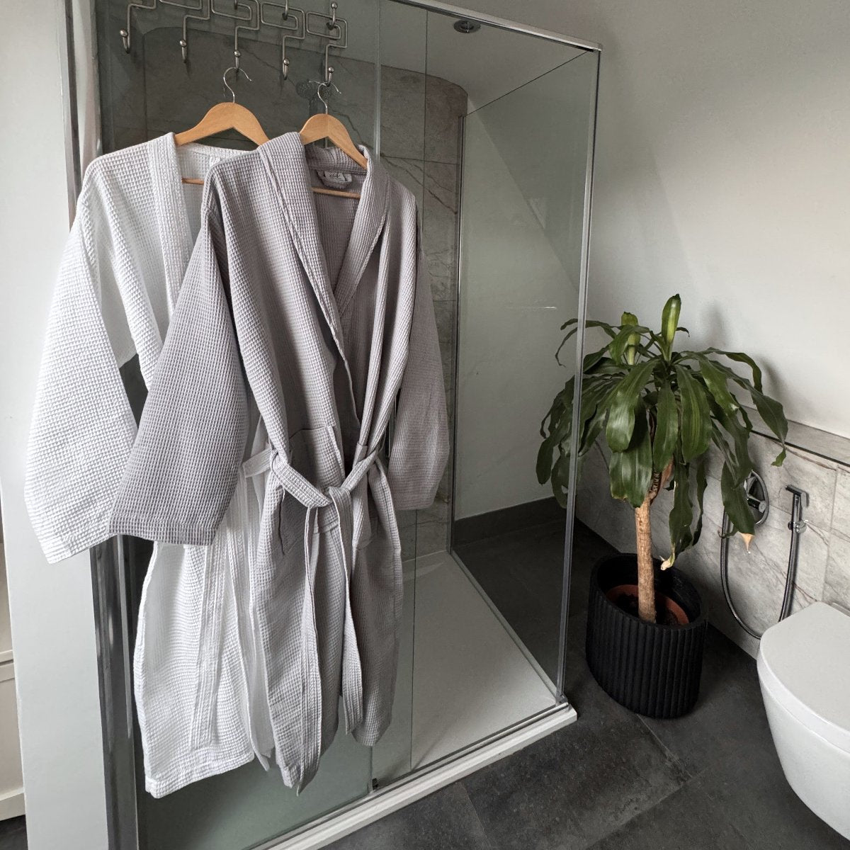 Grey and white hotel style dressing gowns, waffle texture, unisex fit.