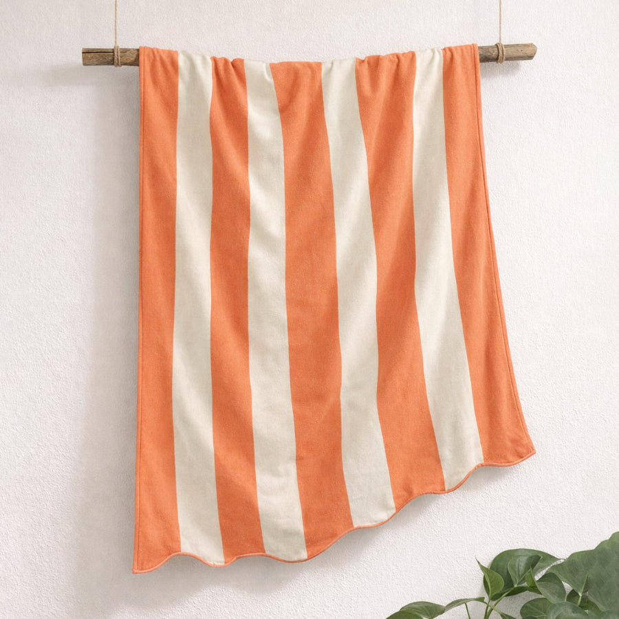 Striped beach towel in orange and white colours, 100% cotton reversible design.