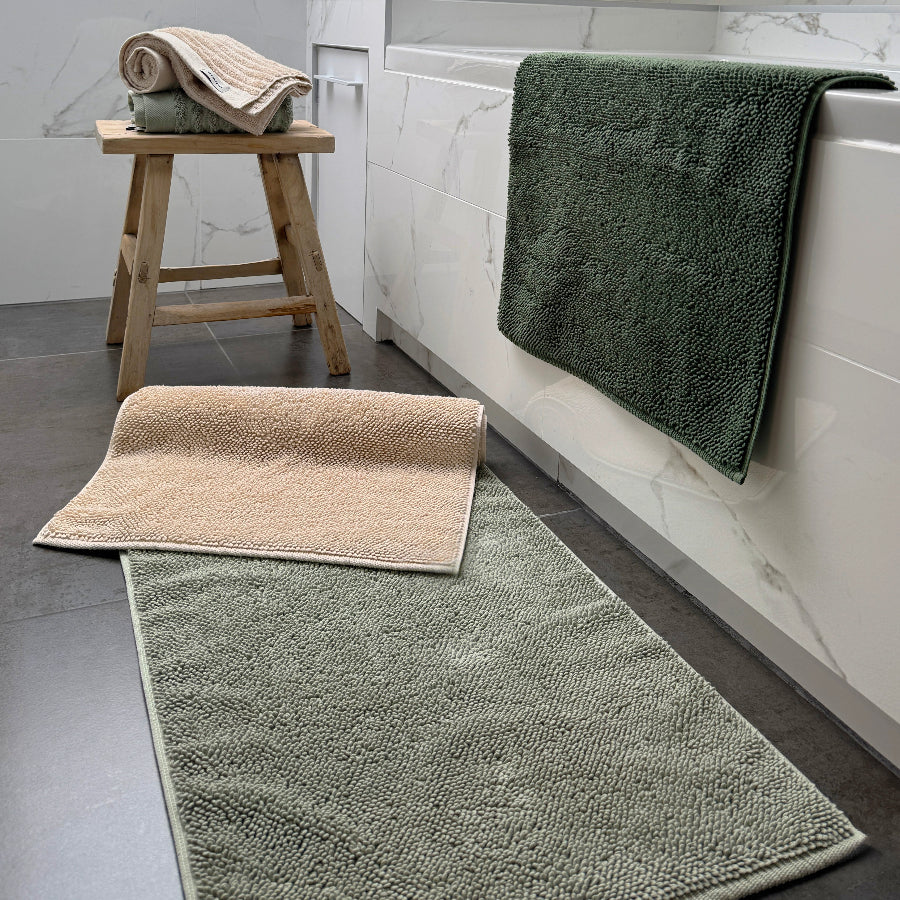 Organic cotton bath mats in neutral colours - sage green, khaki and beige.