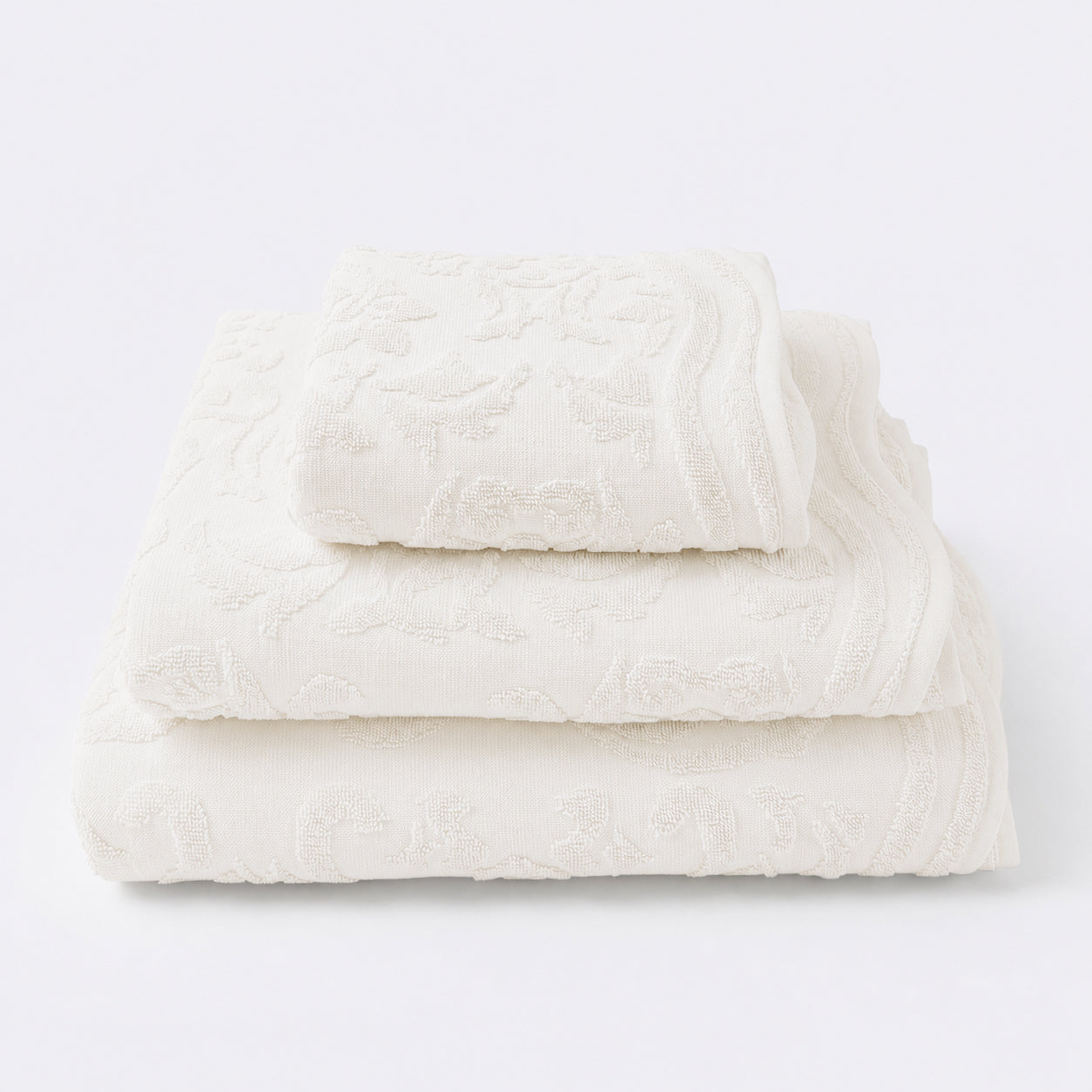 Set of towels for the bathroom with textured floral pattern - hand towel, bath towel and bath sheet in cream colour