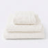 Set of towels for the bathroom with textured floral pattern - hand towel, bath towel and bath sheet in cream colour