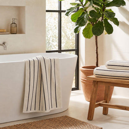 Set of cream and black towels for the bathroom in pinstripe pattern, three sizes - hand towel, bath towel and bath sheet.