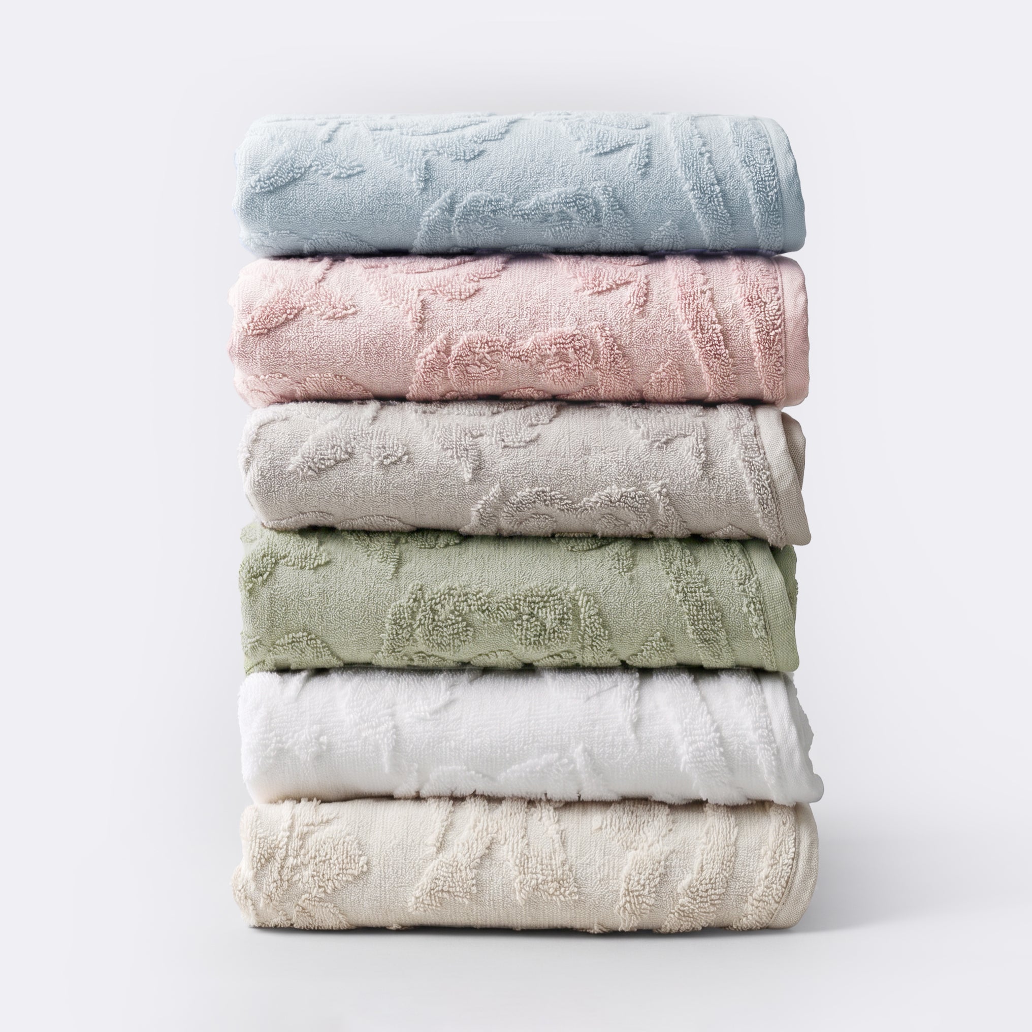 Stack of floral textured towels in a variety of timeless colours.
