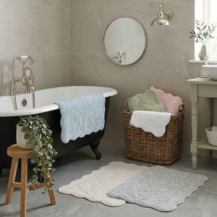 Scalloped bath mats made from cotton, in light, neutral colours. Mats for a rustic farmhouse bathroom.