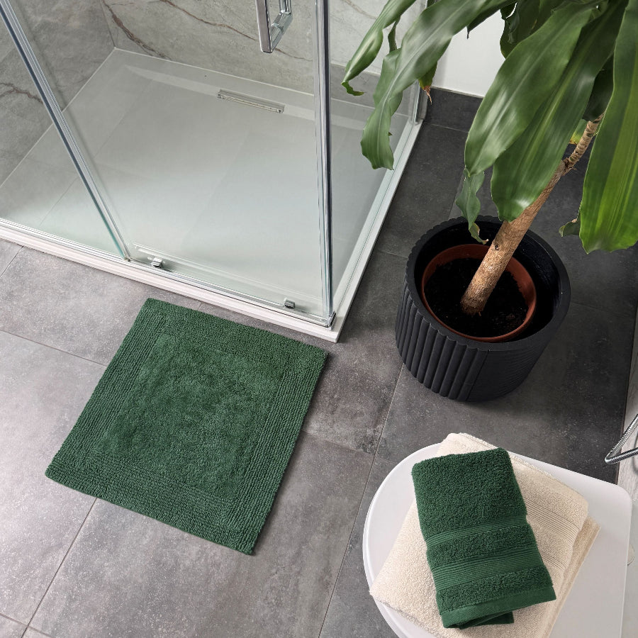 Dark green square bath mat for the shower. Small bathroom rug made from cotton.