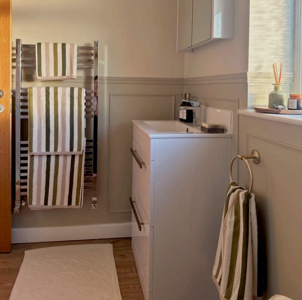 Green stripe towels in a modern bathroom ensuite.