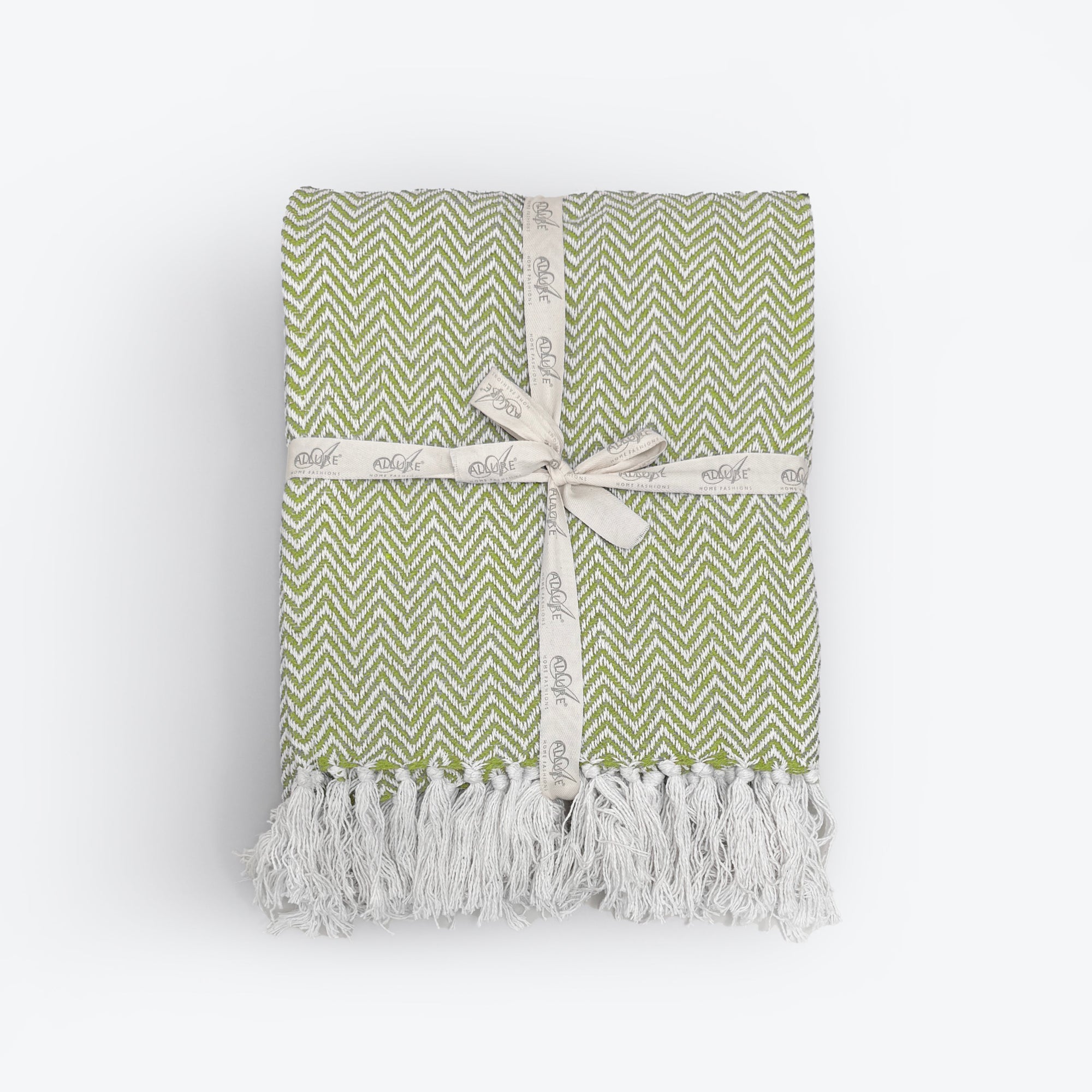 Green patterned blanket with fringe in herringbone chevron design.