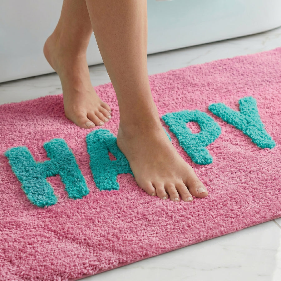 Pink and turquoise colourful bath mat with happy slogan text.