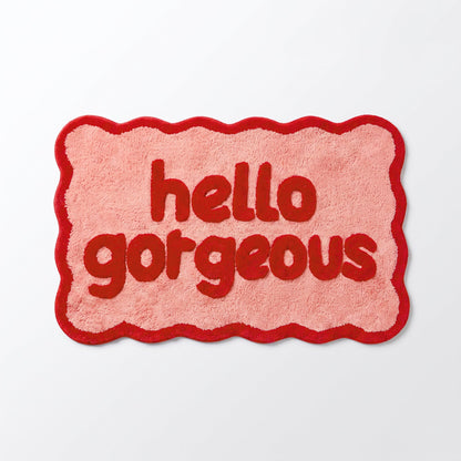 Pink and red bathroom mat with hello gorgeous slogan.
