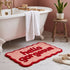 Red and pink hello gorgeous slogan bath mat with fun scalloped edges.