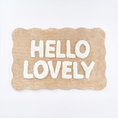 Beige and white scalloped bath mat with hello lovely slogan.