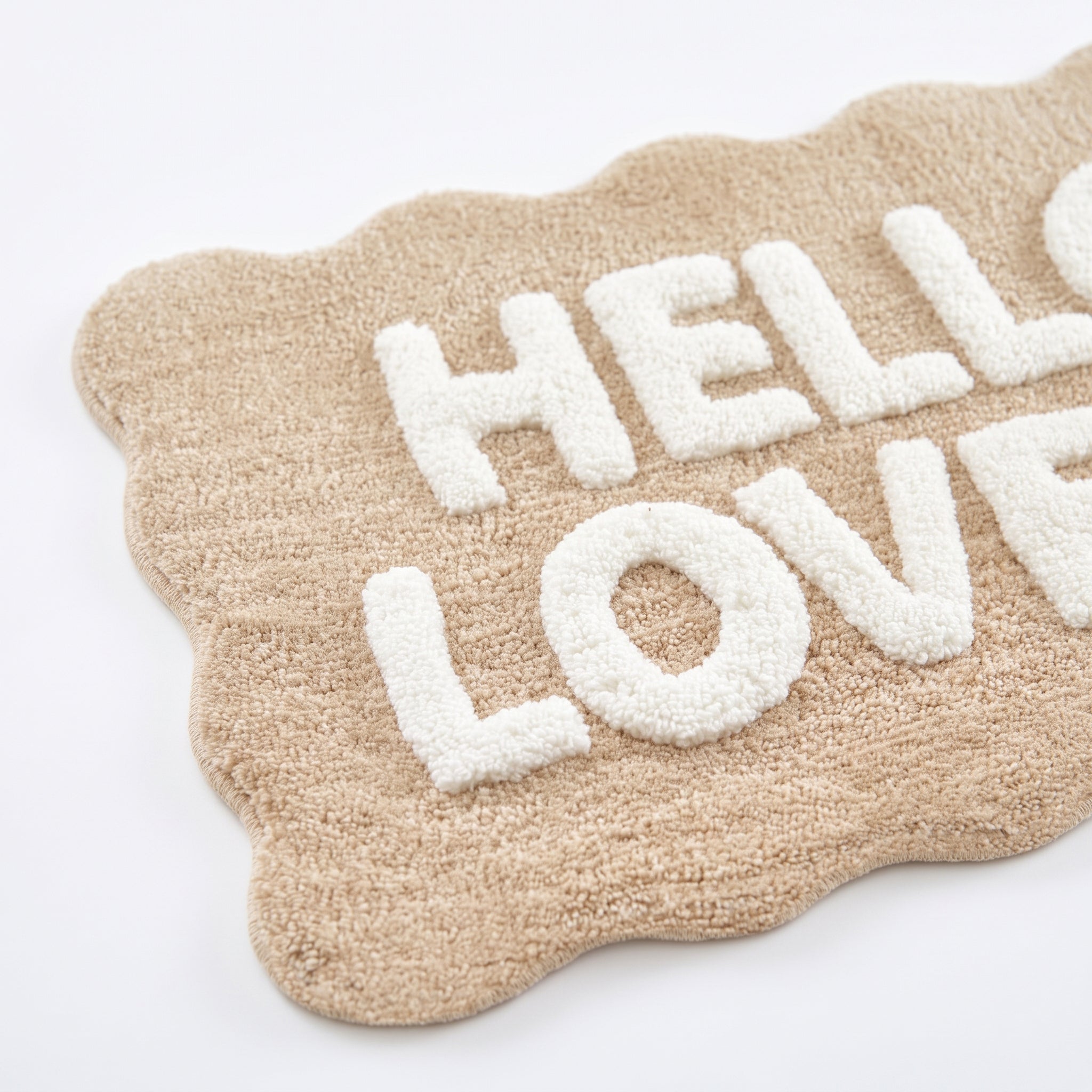 Hello lovely slogan bath mat in beige and white - fun scalloped edging.
