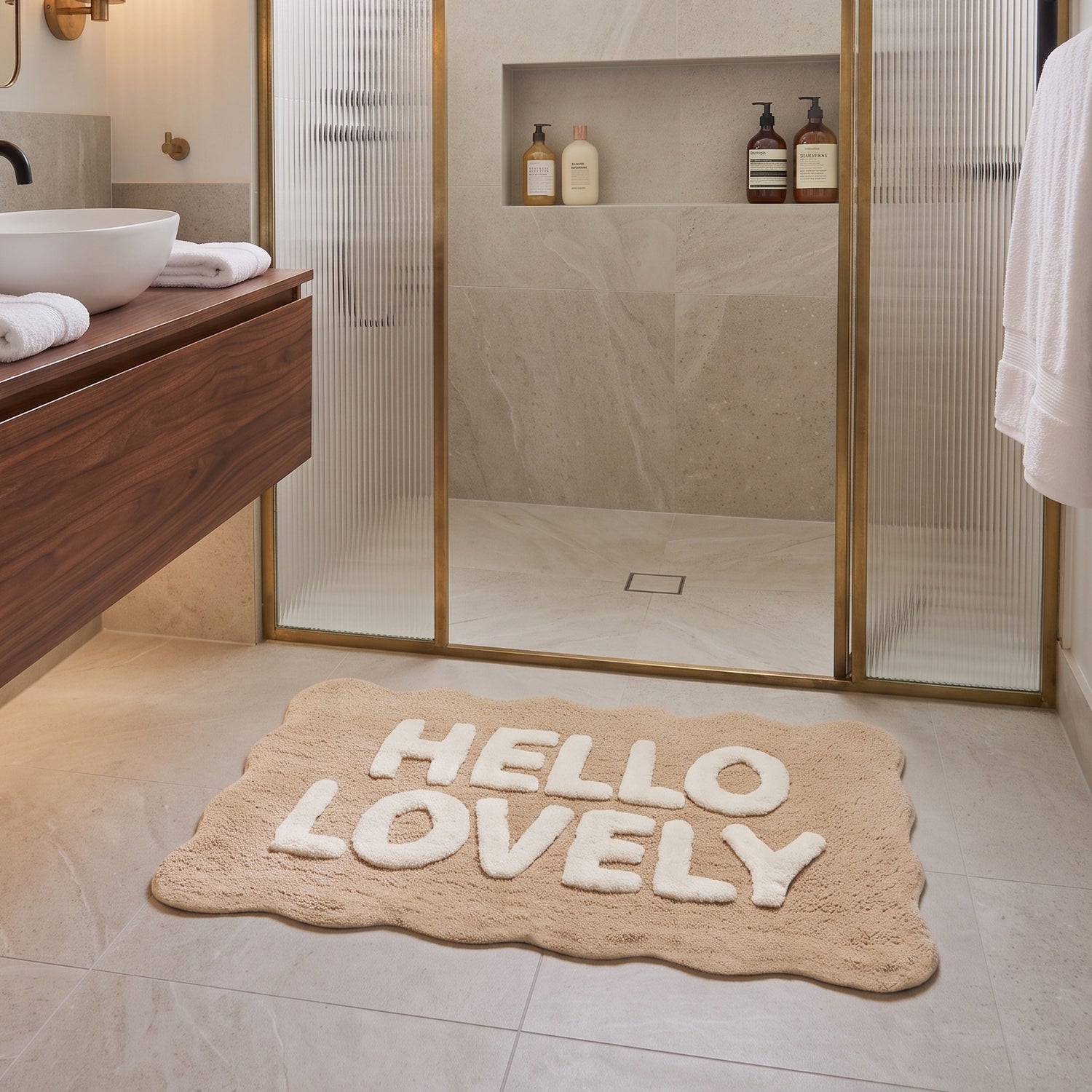 Hand tufted slogan bath mat with hello lovely 3d lettering - neutral bathroom rug with scalloped edges.