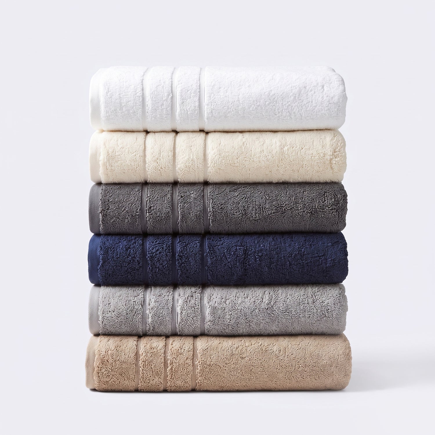 Stack of quality hotel style towels showing the six staple colours. Thick towels made from 100% cotton.