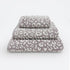 Set of three leopard print towels for the bathroom in various sizes - hand towel, bath towel, bath sheet.