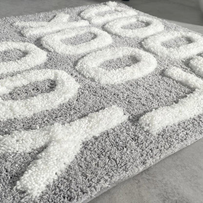 You look good hand tufted slogan bath mat in grey and white.