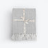 Off white and grey herringbone blanket made from cotton. White chevron throw with tassels. 