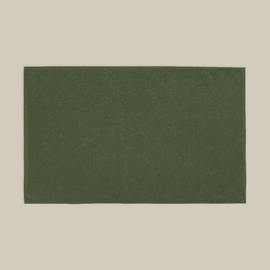 Dark green bath mat made from organic cotton. Soft and sustainable bathroom accessories.