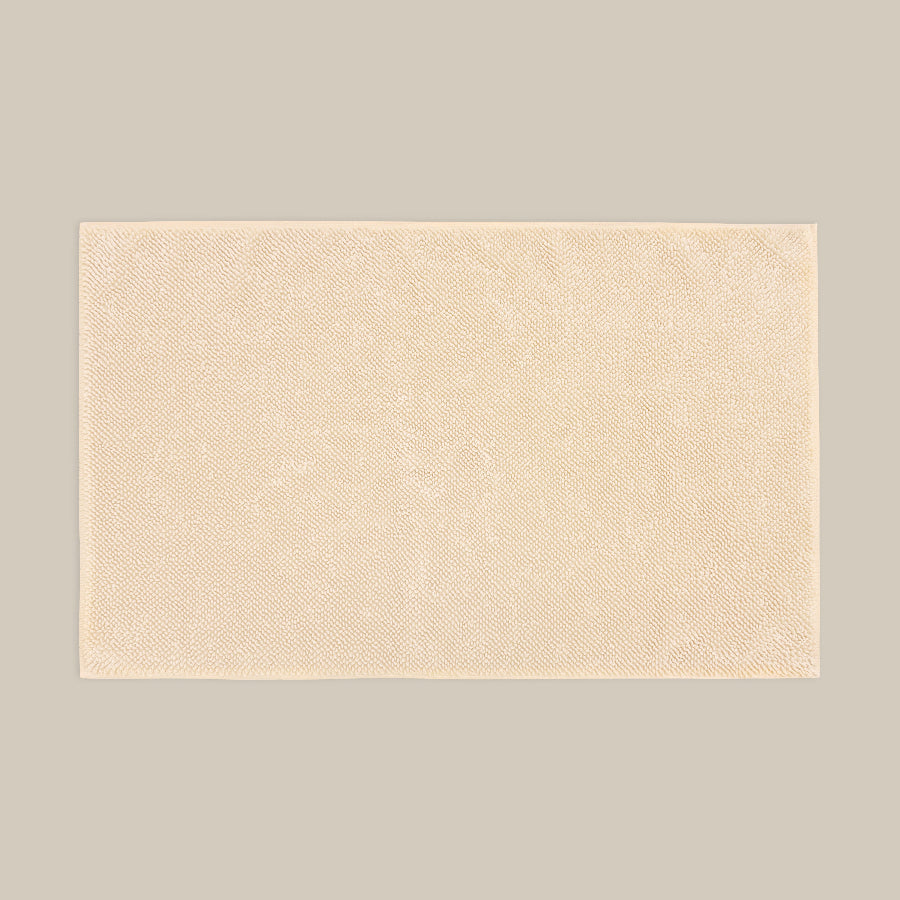 Neutral beige bath mat made from organic cotton. Soft and sustainable bathroom accessories.