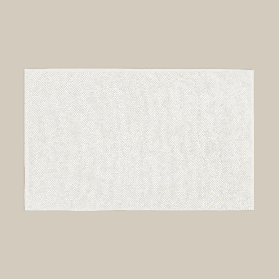 White bath mat made from organic cotton. Soft and sustainable bathroom accessories.