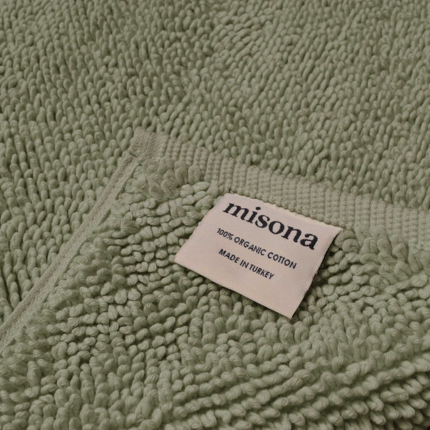 Sage green bath mat made from sustainable organic cotton.