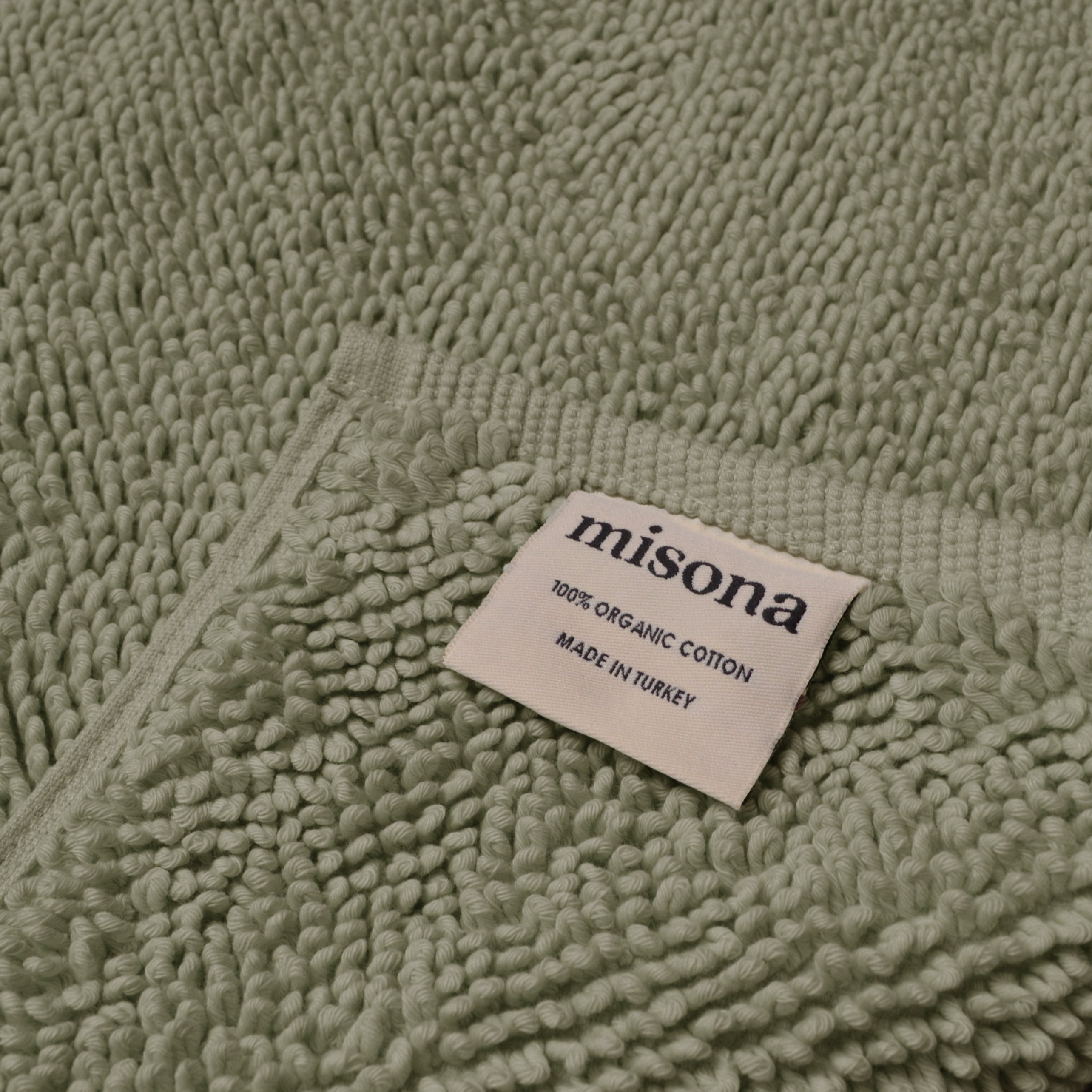 Sage green bath mat made from sustainable organic cotton.