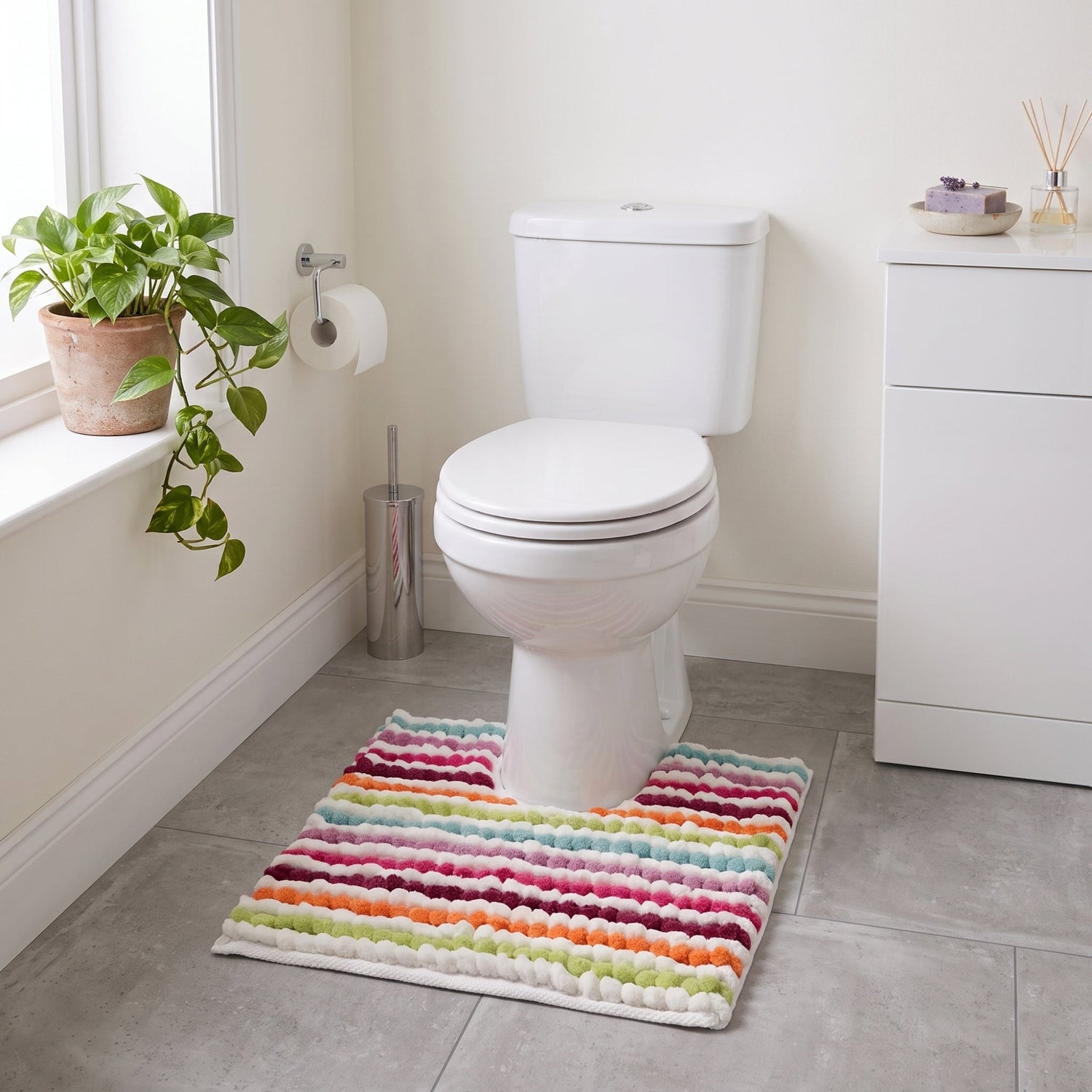 Multi-coloured chunky bobble pedestal mat for the toilet.