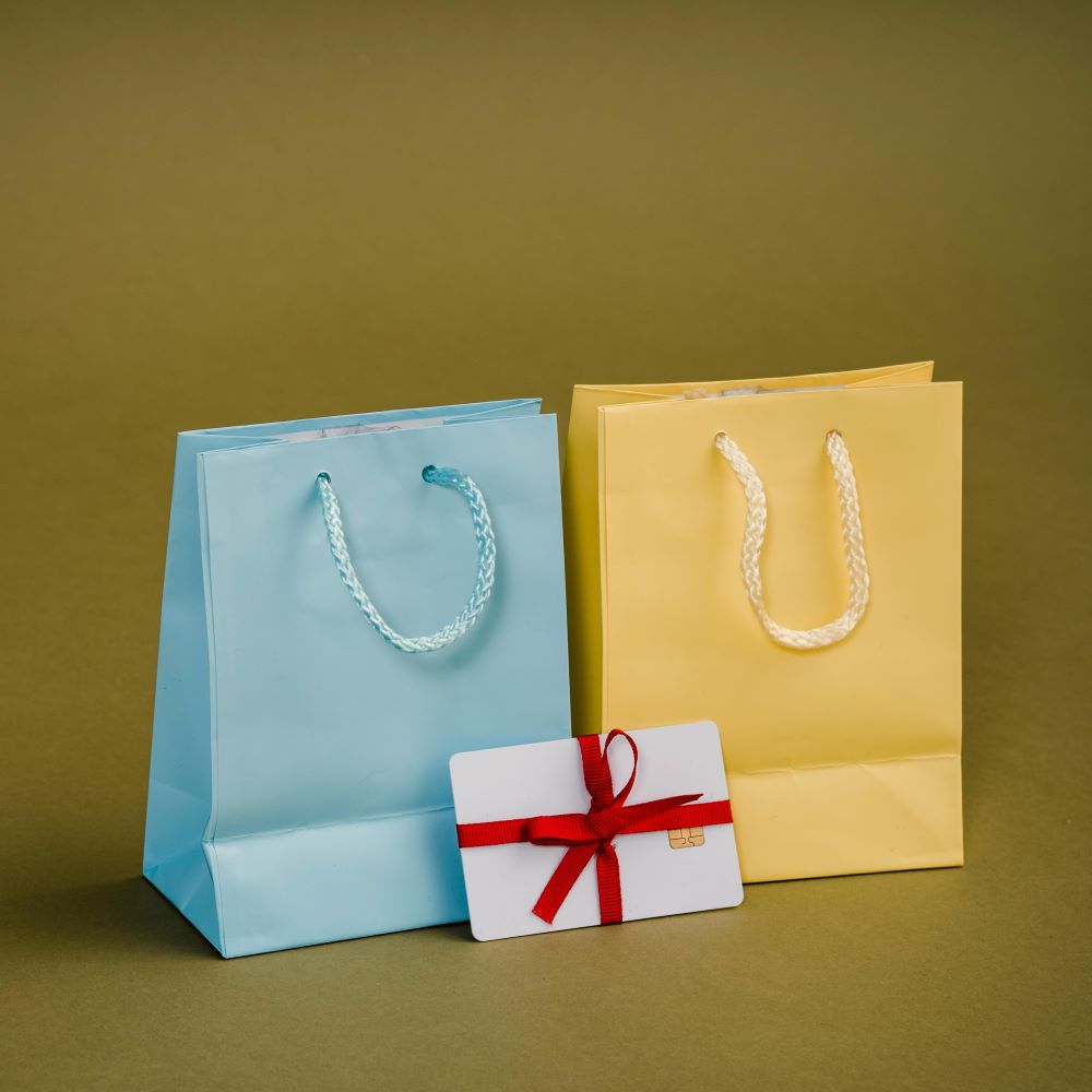 Assorted gift bags with cords on brown background