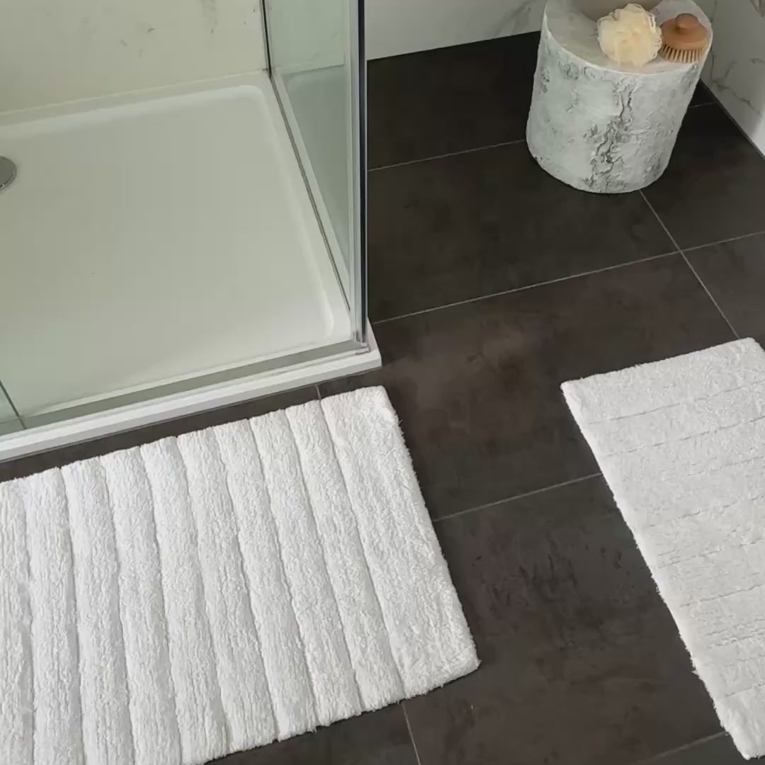 White bathroom mat set, bath mat and shower mat.