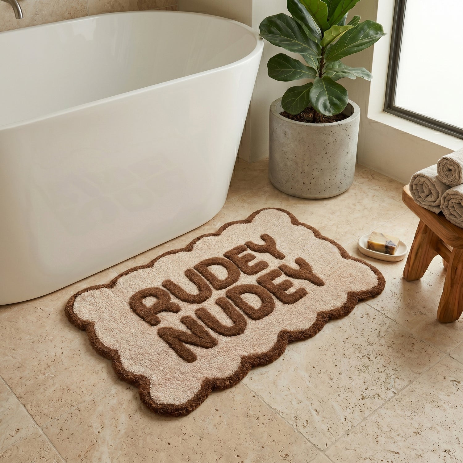 Brown and cream scalloped bath mat with rudey nudey slogan - fun but neutral bathroom styling.