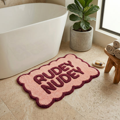 Burgundy and pink slogan bath mat with scalloped edges, funny rudey nudey lettering.