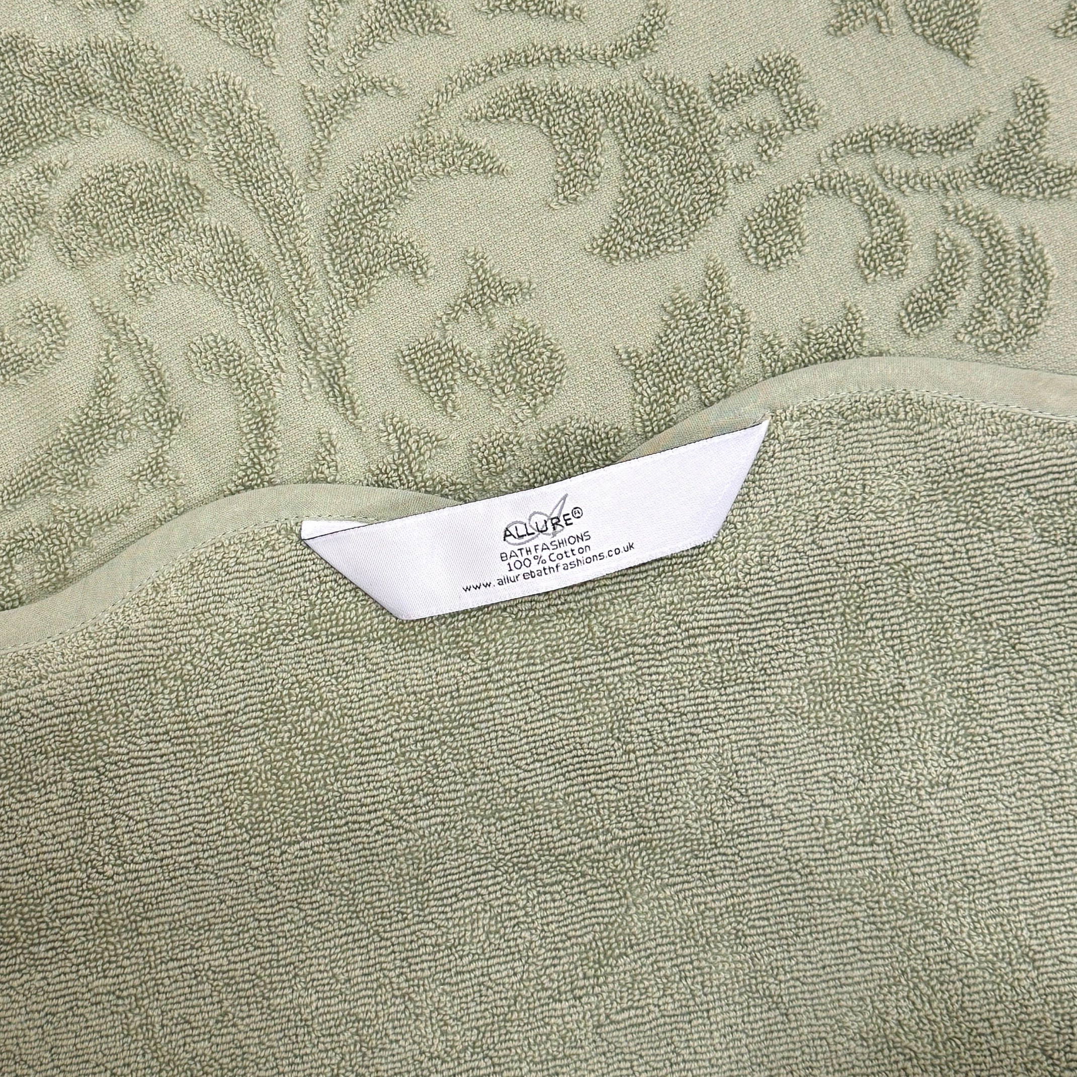Sage green bathroom towels with hanging loops, made from 100% cotton and finished with a floral jacquard pattern.