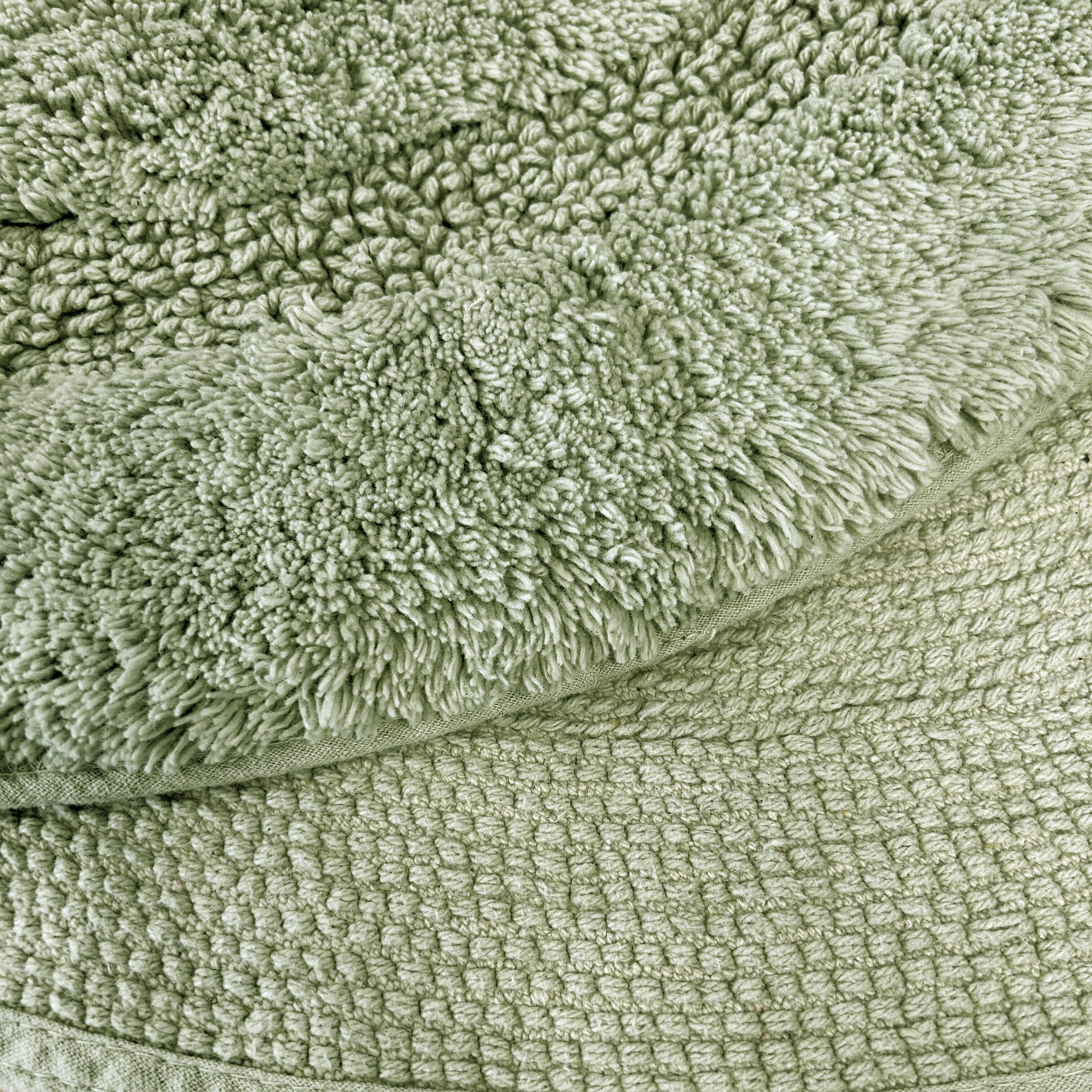 Sage green bath mat close up.