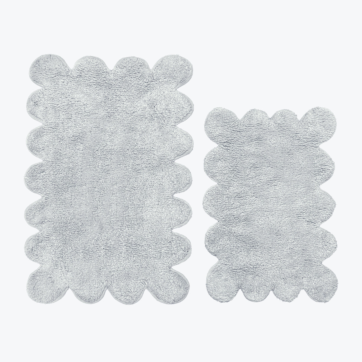 Grey bath mat set in scalloped design, made from 100% cotton.