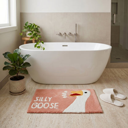 Blush pink novelty bath mat with silly goose character.