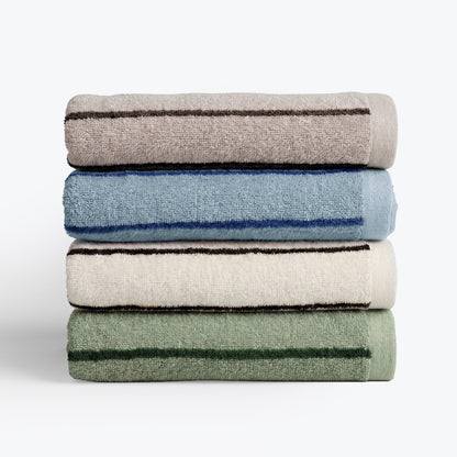 Stack of towels in mixed colours with striped pattern design, beige, blue, cream, green.