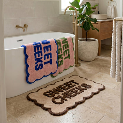 sweet cheeks scalloped bath mats in 3 colours shown in a bathroom setting