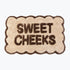 Scalloped bath mat with sweet cheeks slogan in neutral brown and beige colours.