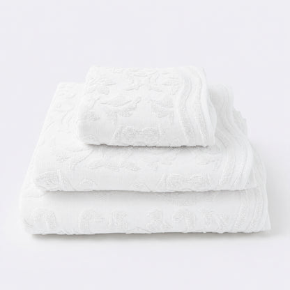 Set of towels for the bathroom with textured floral pattern - hand towel, bath towel and bath sheet in white.