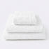 Set of towels for the bathroom with textured floral pattern - hand towel, bath towel and bath sheet in white.