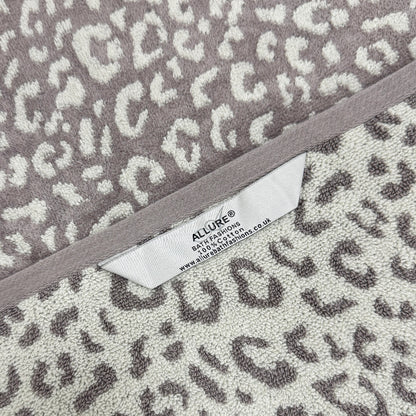 Grey and white patterned leopard towels with hanging loops for quick drying and easy storage.