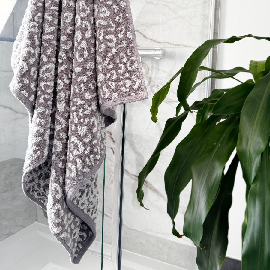 Grey leopard print towel with white spots, made from 100% cotton.
