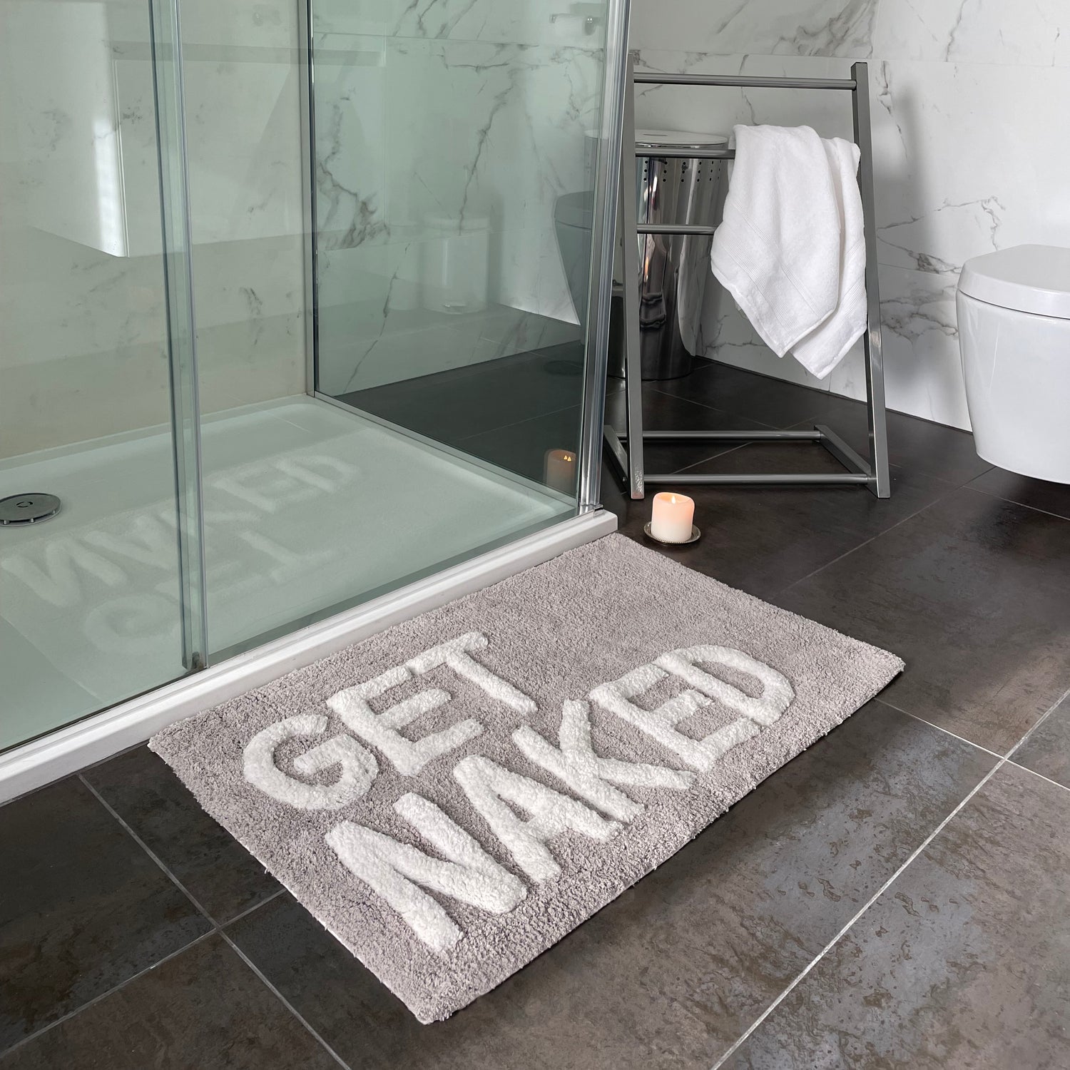 Grey get naked bath mat with white tufted slogan